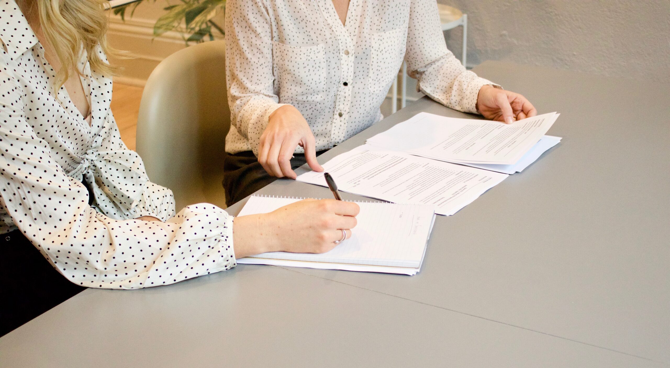 Women looking over document papers at a desk